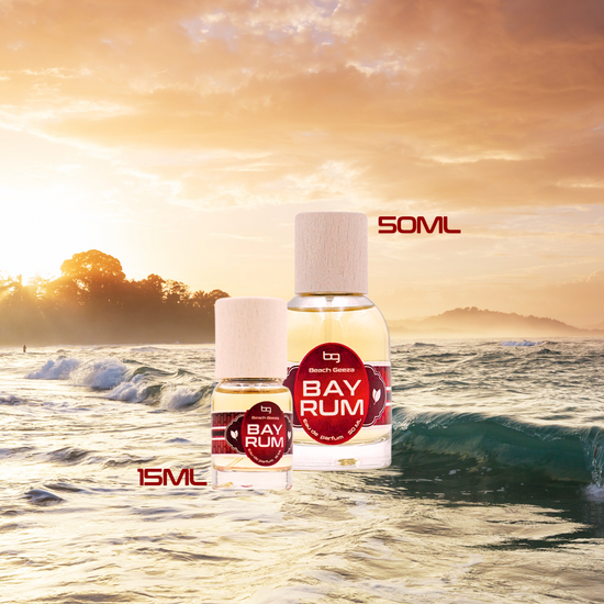 Two Bay Rum bottles with different capacities on a beach at sunset.