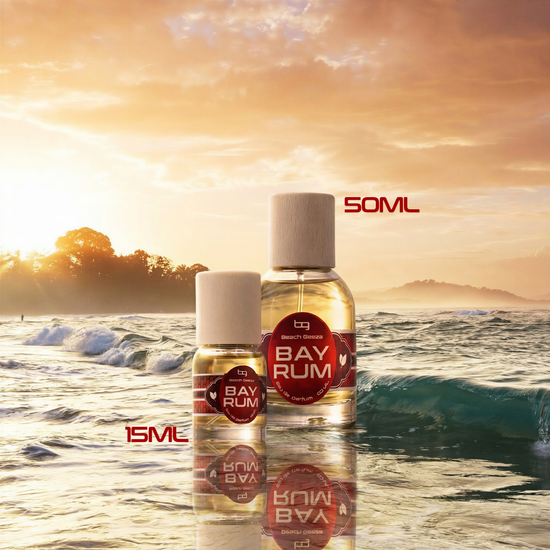 Two Bay Rum bottles with labels on a beach at sunset