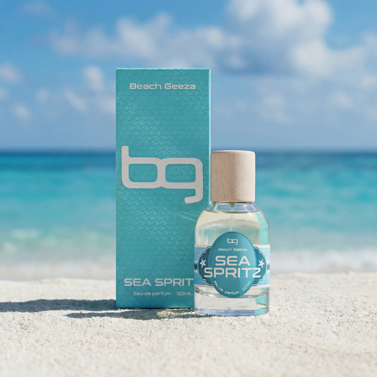 Bottle and packaging of Beach Geeza Sea Spritz on a beach with ocean and sky in the background