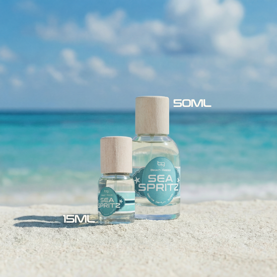 Two bottles of 'Sea Spritz' on a sandy beach with ocean and sky in the background.